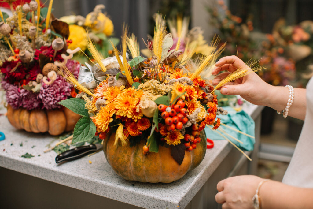 žena dekoruje podzimní plody do dýně