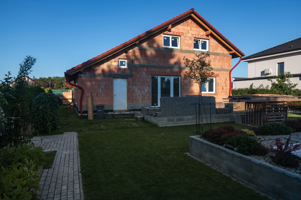 Rozestavěný rodinný dům z jednovrstvého zdiva HELUZ, pohled na hrubou stavbu ze zahrady.