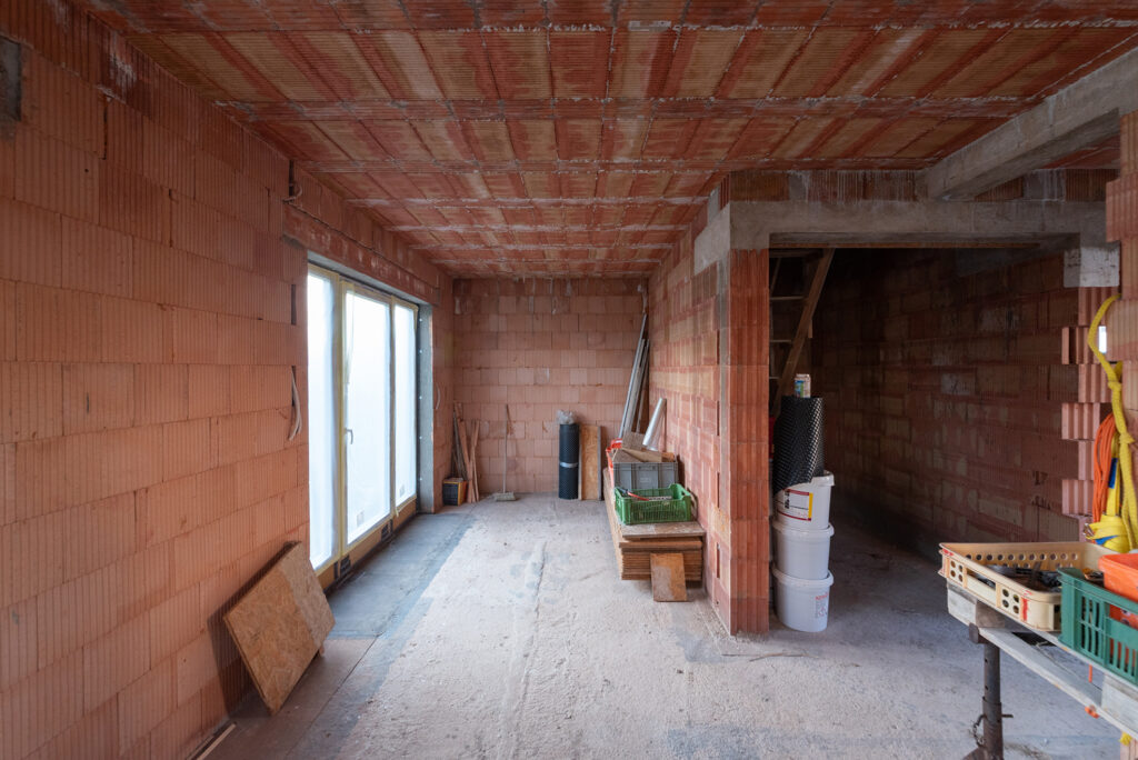 Interiér stavby s jednovrstvým cihelným zdivem HELUZ, místnost ve fázi hrubé stavby.