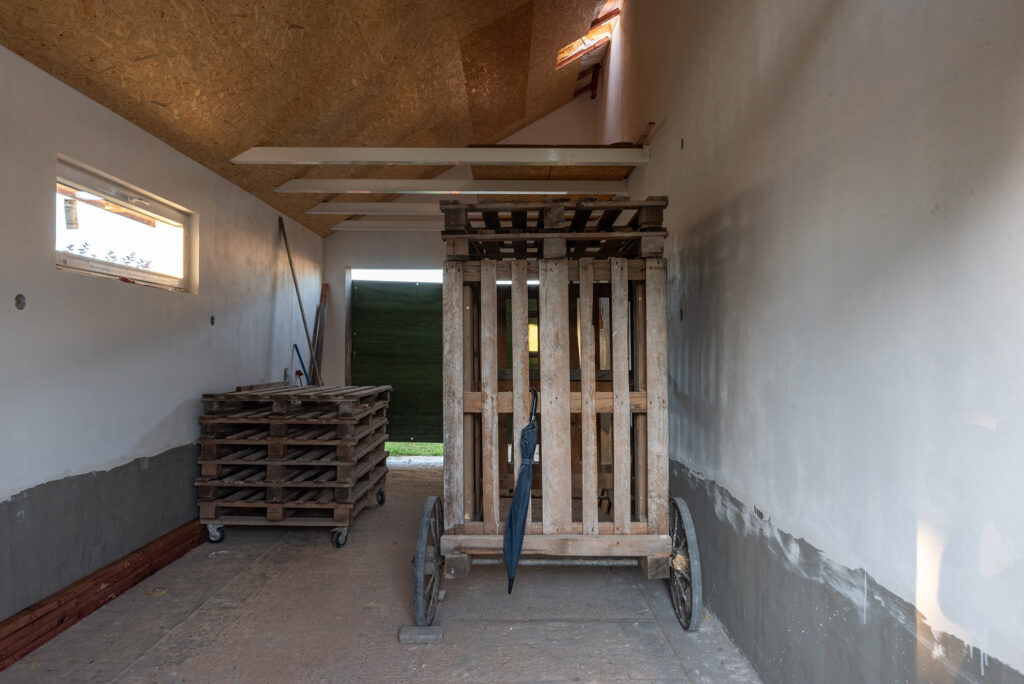 Pohled do garáže s pojízdným lešením, připravené pro dokončovací práce svépomocí.