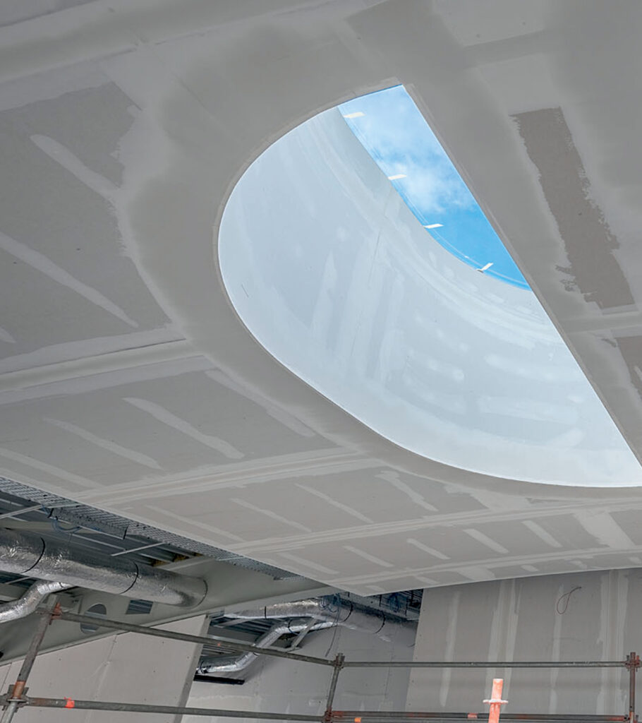 Sádrokartonový strop s velkým obloukovým otvorem a probíhající instalací v interiéru