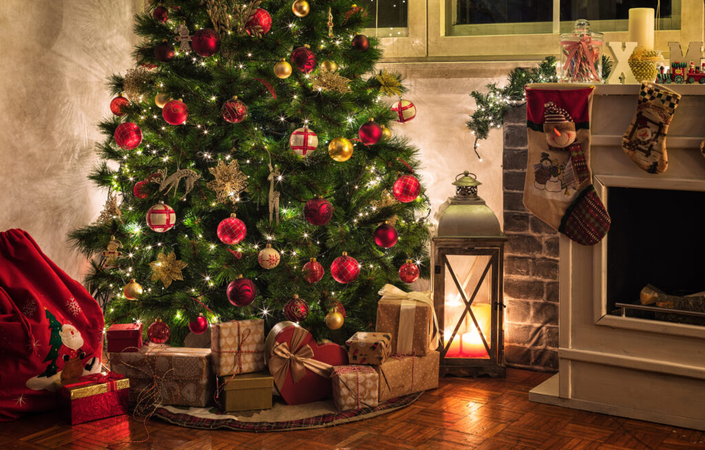 vánoční atmosféra doma s ozdobeným vánočním stromkem a dárky u krbu