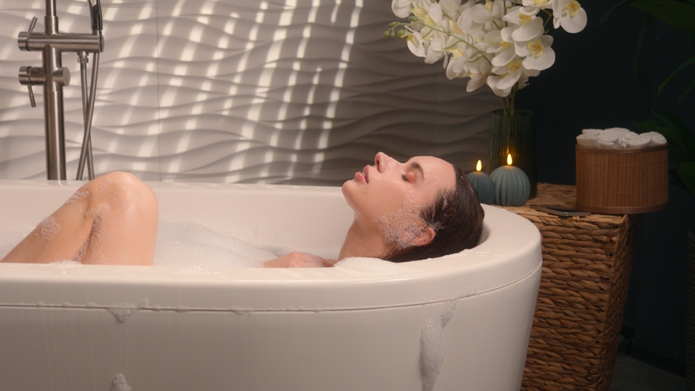 žena se sprchuje pod jemným proudem vody